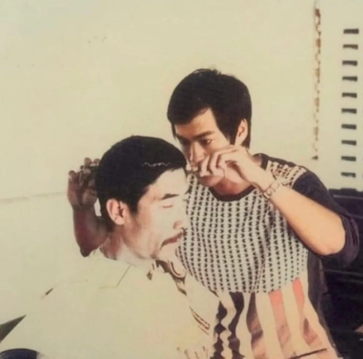 Vintage photo of John applying makeup to another man's face